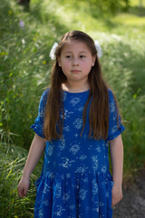 Serious and Thoughtful Little Girl in Blue Dress in front of golden field at Park