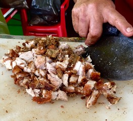 Carnitas de puerco cortándose para tacos