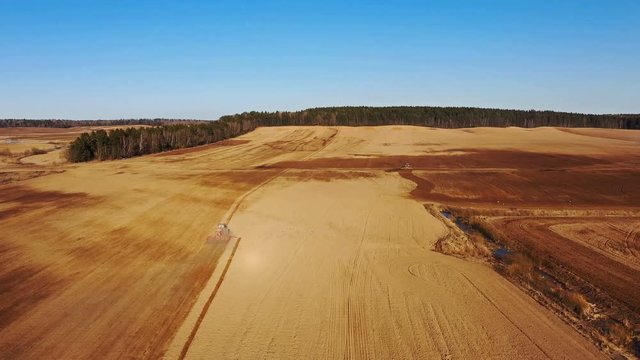 4K. Aerial view of agriculture process: tractors are plows and makes seeding, sowing agricultural crops at field.