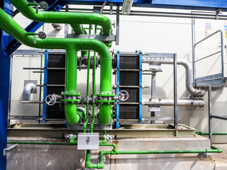 Manual valve and green pipe of cooling water in power plant.