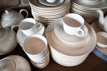 Many white plates are stacked together.a stack of white dish .