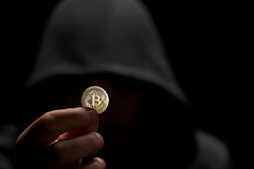 Fototapeta na wymiar Anonimous holding bitcoin in hand