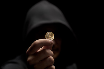 Fototapeta na wymiar Anonimous holding bitcoin in hand