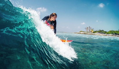 Happy lady surfer rides the tropical wave at sunny day - obrazy, fototapety, plakaty