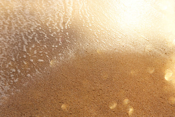 background image of sandy beach and ocean waves with bright bokeh lights