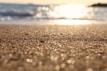 background image of sandy beach and ocean waves with bright bokeh lights