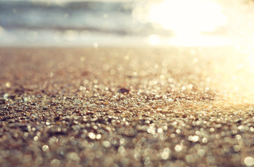 background image of sandy beach and ocean waves with bright bokeh lights © tomertu
