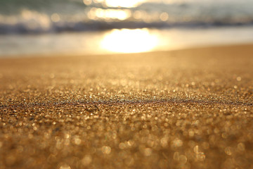 background image of sandy beach and ocean waves with bright bokeh lights
