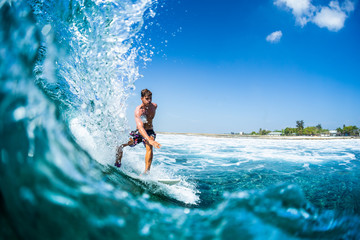 Surfer rides barreling tropical ocean wave - obrazy, fototapety, plakaty