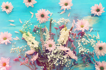 spring bouquet of pink and white flowers over blue vintage wooden background. top view, flat lay