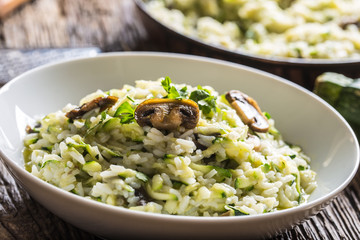 Italian risotto zucchini mushrooms and parmesan in white plate