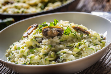 Italian risotto zucchini mushrooms and parmesan in white plate