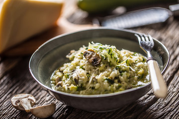 Italian risotto zucchini mushrooms and parmesan in dark plate - Powered by Adobe