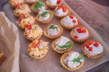Tasty and juicy snacks for buffet table: mini burgers, canapés, fruit, sliced and baked