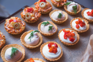 Tasty and juicy snacks for buffet table: mini burgers, canapés, fruit, sliced and baked