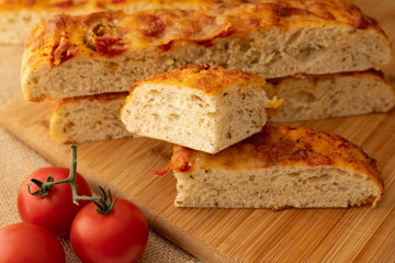 Focaccia, Italian Homemade Bread, and Tomatoes Close Up on a Wooden Chopping Board