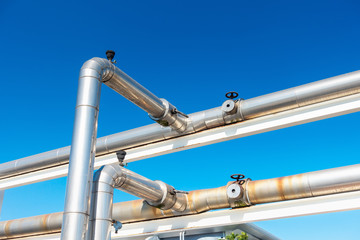 Cooling Chiller or Steam Pipeline and Insulation of Manufacturing in Oil and Gas Industrial, Petrochemical Distribution Pipe at Refinery Plant. Overhead Steel Pipe Support on Blue Sky Background.