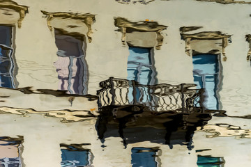 Reflection of houses on the waterfront in the water of the river