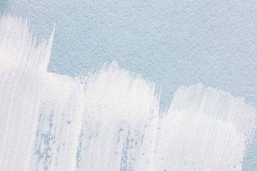 white brush strokes texture on light blue paper background. macro
