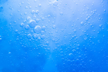 Air bubbles in the water background.Abstract oxygen bubbles in the sea.Circle foamy air in the ocean.Water bubbles isolate on blue background