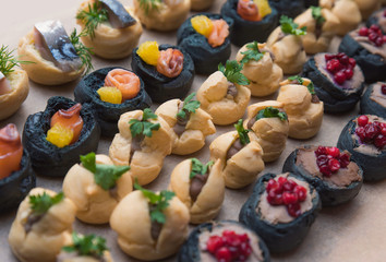 Tasty and juicy snacks for buffet table: mini burgers, canapés, fruit, sliced and baked