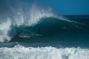 Naklejka premium Extreme surfer rides gigantic ocean wave of the Banzai Pipeline surf spot. The North Shore of Oahu, Hawaii
