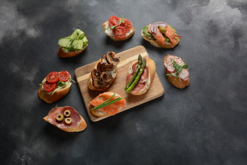 Brushetta or traditional Spanish-tapas. Appetizers with Italian antipasti snacks. Variety of small sandwiches with prosciutto,cherry tomatoes, salmon, cream cheese, cucumber, radish, asparagus