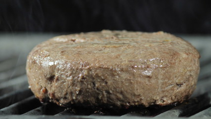 A big juicy cutlet in half-ready grilled in a restaurant, light smoke from the coals enveloping the cutlet