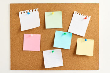 Cork board with a colored paper blank notes, close up