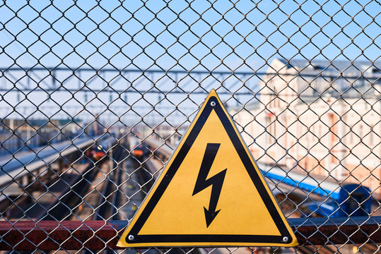 Electrical hazard sign. Lightning on yellow background close up. High voltage electricity on a railway station