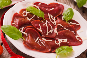 Red heart ravioli with tomato, mozzarella and basil.