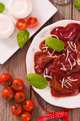 Red heart ravioli with tomato, mozzarella and basil.