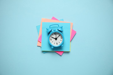Blue alarm clock and paper reminder. Time management, priorities, efficiency, control and goals.
