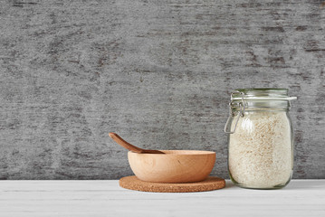 Rice grains in glass jar and wooden bowl