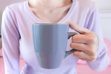 Woman hands holding coffee cup. Girl in sweater holding mug. Morning drink lifestyle.
