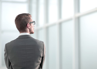 rear view.businessman standing near the office window