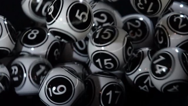Black and white lottery balls in a machine slow motion