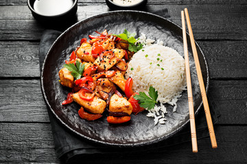 Plate of asian food, rice with chicken meat and vegetables .