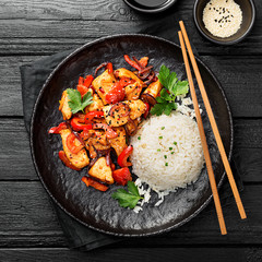 Plate of asian food, rice with chicken meat and vegetables .