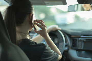 Distracted woman talking on her phone while driving.