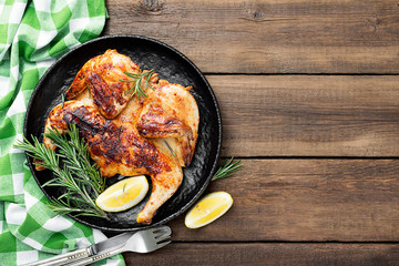 Grilled chicken Tabaka with sauce on  wooden background.