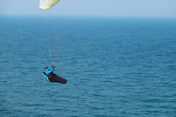 some paragliders fly along the steep coast of the Baltic Sea