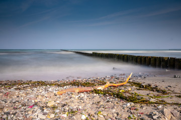 long groynes protrude into the water of the blue Baltic Sea
