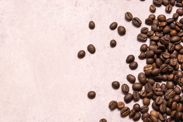 Roasted coffee beans in bulk on a light pink background. dark cofee roasted grain flavor aroma cafe, natural coffe shop background, top view from above, copy space