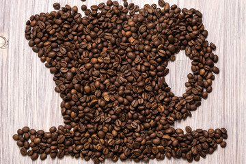 Roasted coffee beans like a cup on a wooden background