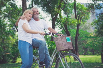 Naklejka na ściany i meble Senior Couple Riding Bikes In Park