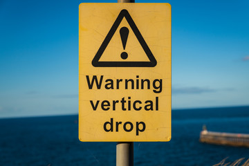 Sign: Warning vertical drop, seen in Whitby, North Yorkshire, England, UK