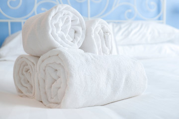 Fresh and clean nicely rolled up towels lie on a bed