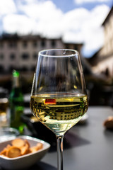 White italian wine on a wineglass on an outdoor restaurant terrace