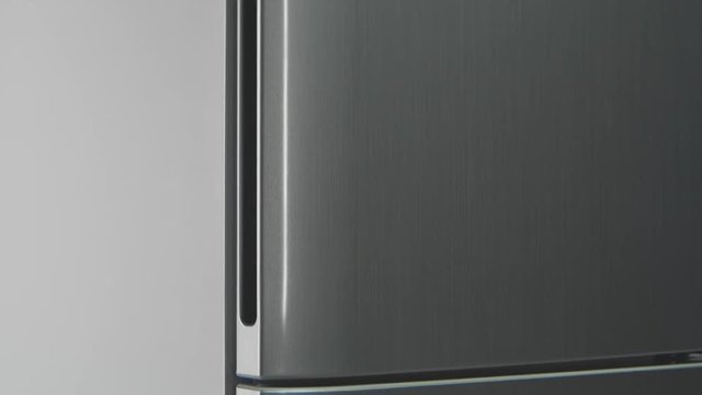 motion along modern grey refrigerator with closed doors